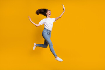 Fototapeta na wymiar Full length body size photo of pretty woman taking selfie throwing hair jumping up isolated on bright yellow color background