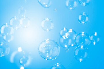 Abstract, Beautiful shiny transparent soap bubbles float on a blue texture background. Natural freshness summer holiday background.