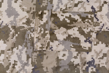Fragment of pants of pixellated digital camouflage fabric with pocket