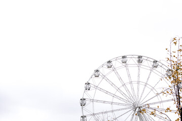 Modern white Ferris wheel in the central park against sky. Entertainment, attraction, amusement park, minimal concept. Banner.