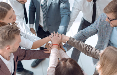 group of young business people putting their hands together.