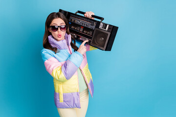 Photo portrait of amazed pouting woman pressing pause button on boombox carrying on shoulder isolated on pastel blue colored background © deagreez