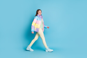 Fototapeta na wymiar Full length profile photo portrait of walking girl isolated on pastel blue colored background