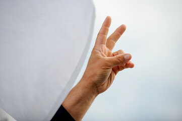 Fototapeta premium Details with the hand of a protestor showing the victory sign during a political rally.