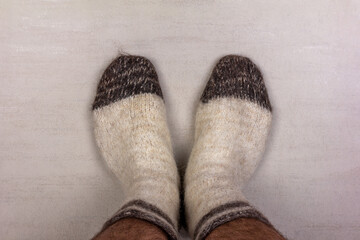 men's feet in white knitted wool socks close-up, top view