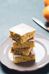 Portion  of orange cake with spice  on wooden table.