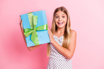 Photo of optimistic blond girl hold present wear white dress isolated on pastel pink color background