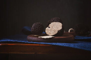 Black truffle on dark wooden board.