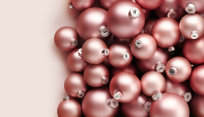 Christmas decorations, top view of pile of glass balls colored in blush pink, isolated on pink background, useful as a greeting gift card template