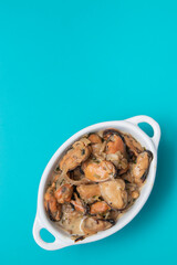 Mussels without shell slices in white ceramic bowl. Seafood concept. Selective focus. Space for text