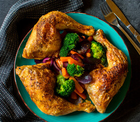 chicken legs  with vegetables directly above on a plate
