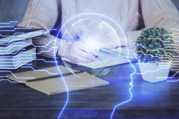 Multi exposure of writing hand on background with brain hologram. Concept of learning.