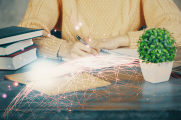 Social network theme hologram over woman's hands writing background. Concept of international people connect. Double exposure