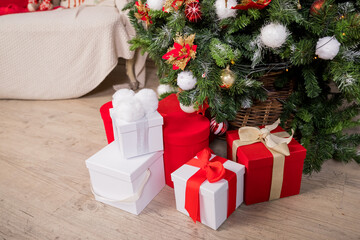 Christmas gift boxes and shopping package under Chrismas tree.New year present paper package. gift packages with ribbons.New year's gifts stand under Christmas tree with toys. Background for website.