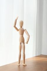 Wooden mannequin on table in room
