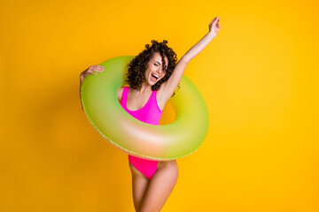 Photo portrait of young woman in pink swim wear holding green inflatable ring cheering for victory...