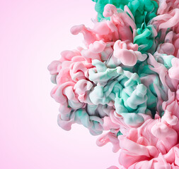 Fototapeta premium Abstract paint splash in water over pink backdrop