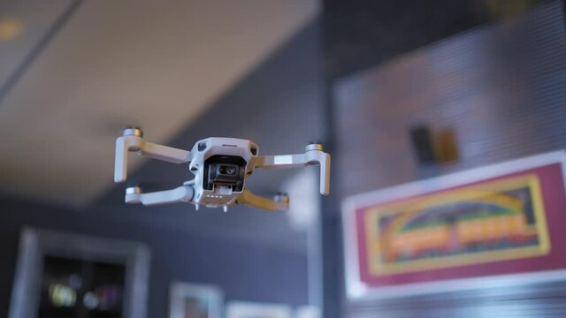 A small drone weighing 249 grams close-up on a blurred background at home, the drone camera shoots in 4 K