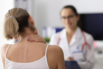 Woman complains of neck pain to doctor. Pain in the cervical spine concept