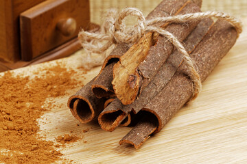 Ground cinnamon and cinnamon bark on a wooden background