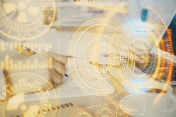 Technology theme hologram with man working on computer on background. High tech concept. Double exposure.