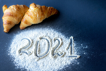 2021 new year numbers in the background two croissants