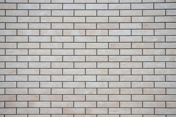 Textured white and brown brick wall with stone texture and gray seams. decorative tiles for wall decoration. Artificial stone. Background, texture