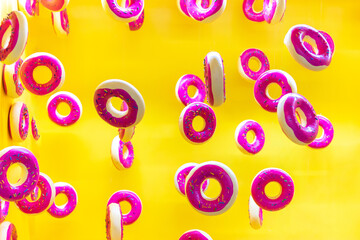 sweet donuts floating on yellow background