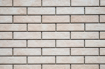Textured white and brown brick wall with stone texture and gray seams. decorative tiles for wall decoration. Artificial stone. Background, texture
