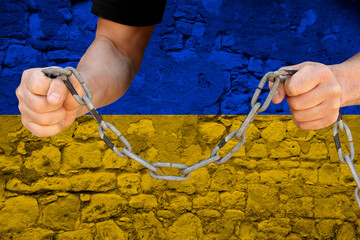 male hands break the iron chain, a symbol of tyranny, protest against the background of the state...