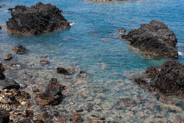 Blue ocean waves with rocks on the beach
