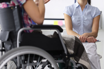Fototapeta na wymiar Woman in a wheelchair in consultation with psychologist. Psychological assistance to people with disabilities concept