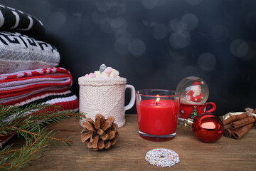 warm colored sweaters, a cup of hot cocoa with marshmallows, candles, gifts, sweets, the concept of merry christmas, cozy winter mood, holiday