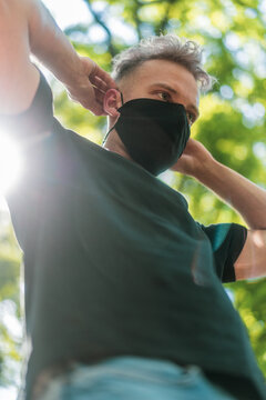 young man wearing a black face mask in forest in summer