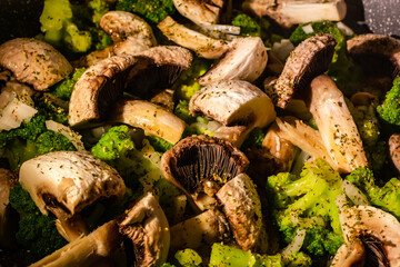 White champignons, onion and green broccoli fry on pan or wok. Hot delicious vegetarian dinner.