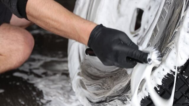 Male worker wash the car. Cleaning Car Using High Pressure Water.