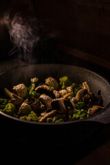 White champignons, onion and green broccoli fry on pan or wok. Hot delicious vegetarian dinner.