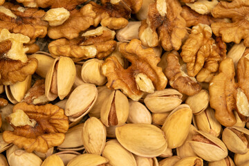 Pistachios and walnuts lie on the sacking. Close up.