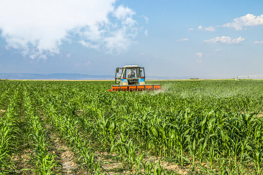 Tractor in the field applies fertilizer to the soil
