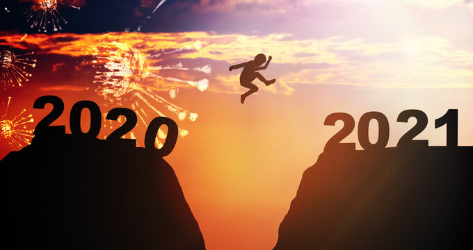 Silhouette kid boy child jump between 2020 and 2021 years with sunset sky background.Fight Covid19 pandemic year with hope.Happy new year 2021. Vaccine Success.New normal New year.banner background.