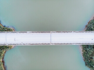 Top-down aerial view long white bridge. Aerial bird's eye view seascape and bridge background....