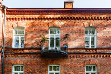 Beautiful vintage red brick building with balcony at sunny day