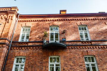 Beautiful vintage red brick building with balcony at sunny day