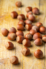 Top view of hazelnuts on rustic table, with selective focus, in vertical, with copy space