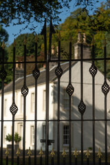 Wrought Iron Gate With An Elegant Mansion House in the Background