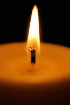 vertical wallpaper background burning candle in the dark close up