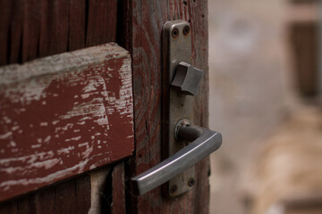 old wooden red door with a metal handle