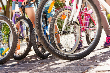 Close-up picture of kids bicycles standing on the cobblestone paved road