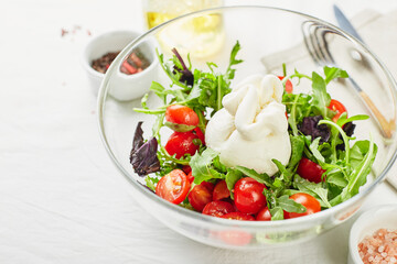 Burrata, Italian fresh cheese made from cream and buffalo or cow milk, with tomato, arugula and red basil salad