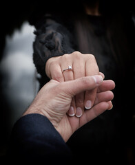 close up couple hands man holding happy fiance hand with diamond engagement ring on her finger after wedding proposal at tropical beautiful and romantic spot proposing marriage